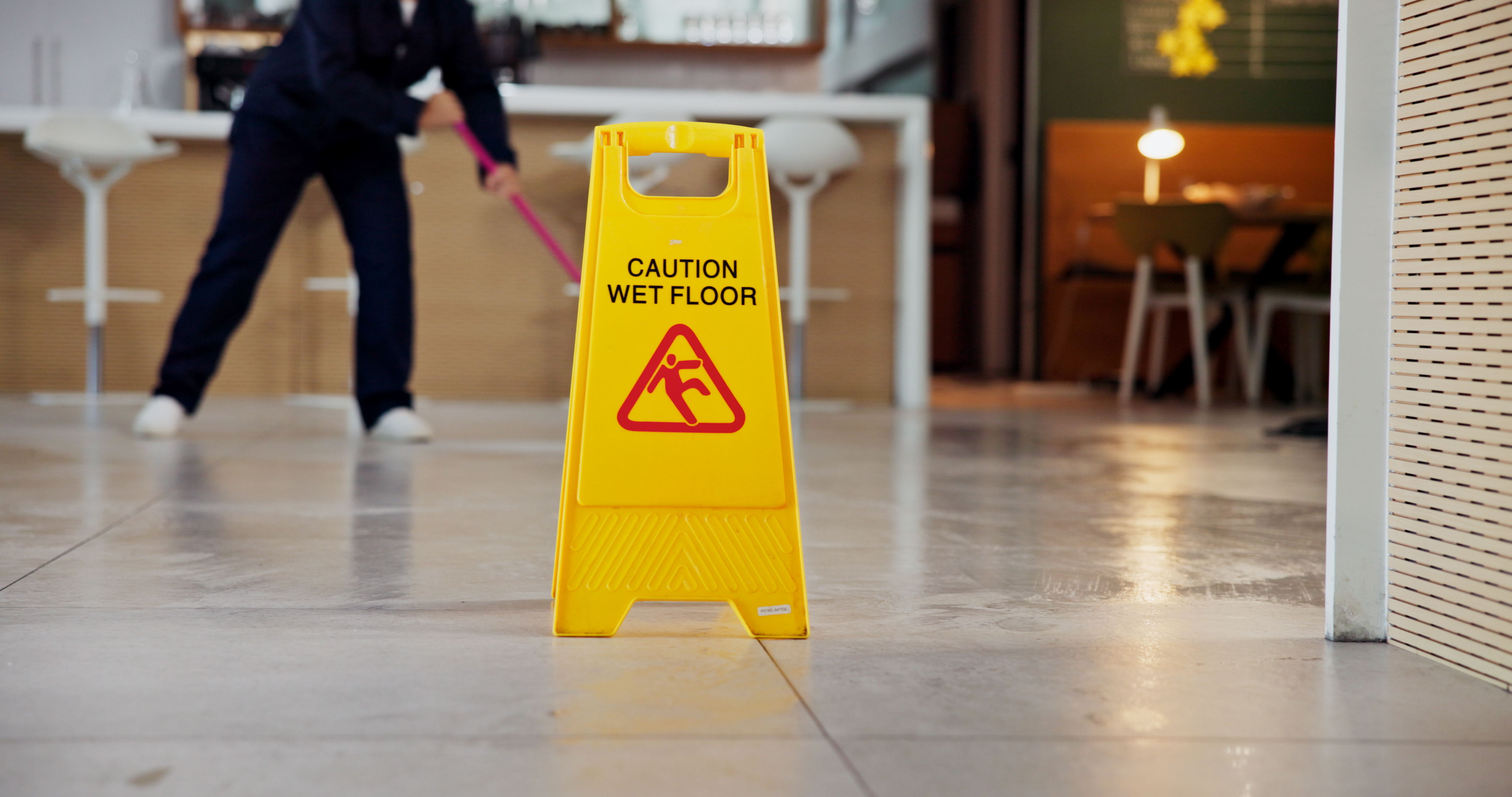 Cleaning, business and caution for wet floor, warning and person with equipment for service or sign